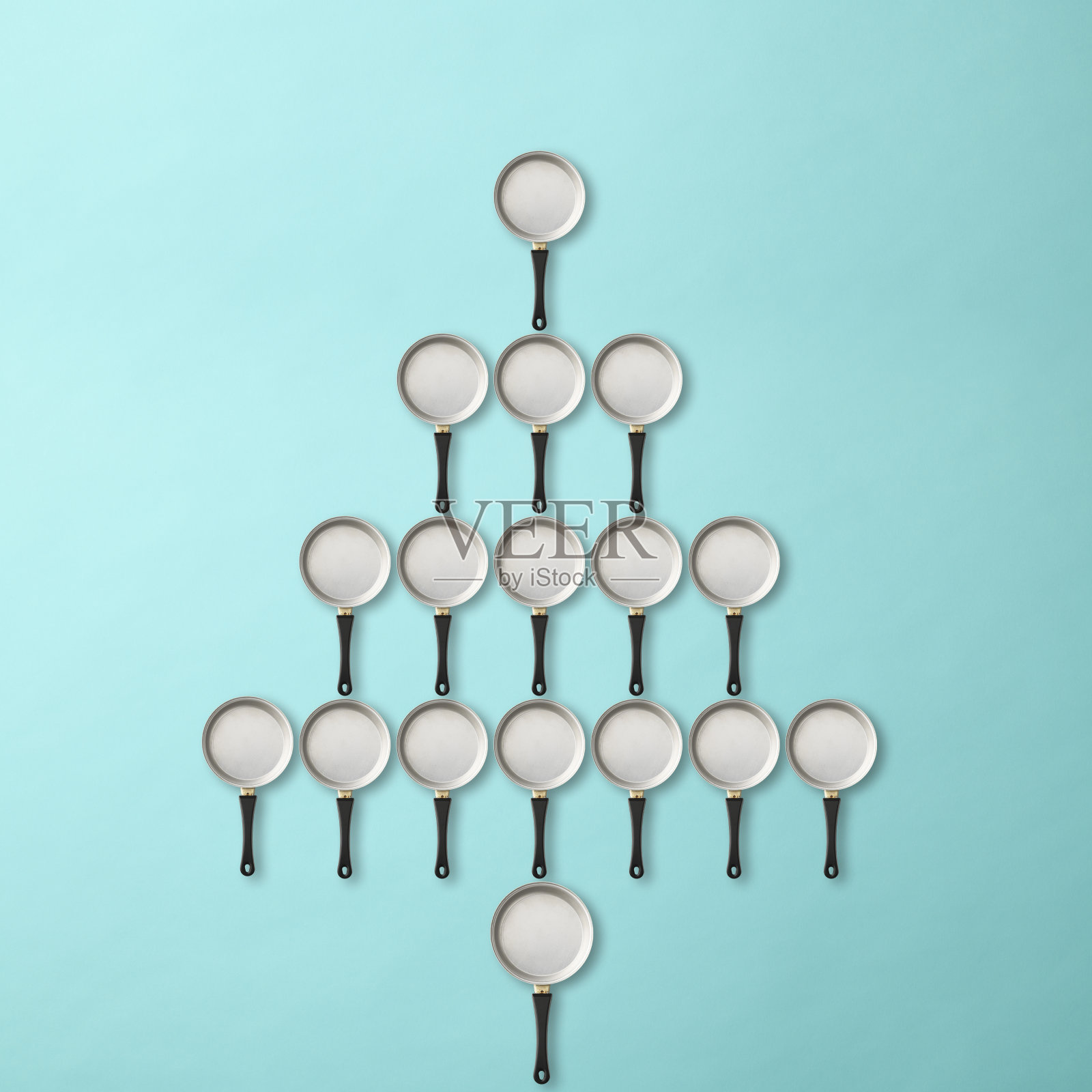 圣诞树是用一个空煎锅做成的，背景是浅蓝色的照片摄影图片