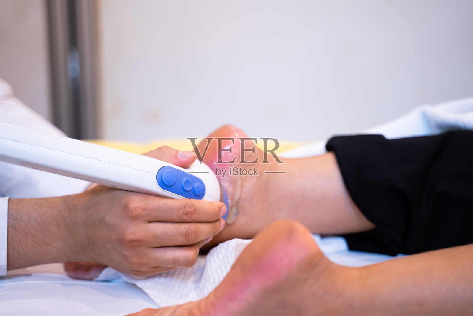 专家使用足部按摩器进行足部按摩。水疗程序足部按摩健康和放松的身体护理概念照片摄影图片