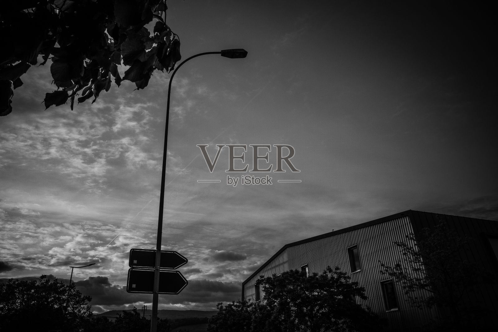 在多云的天空下，黄昏时的街道标志黑白照片照片摄影图片