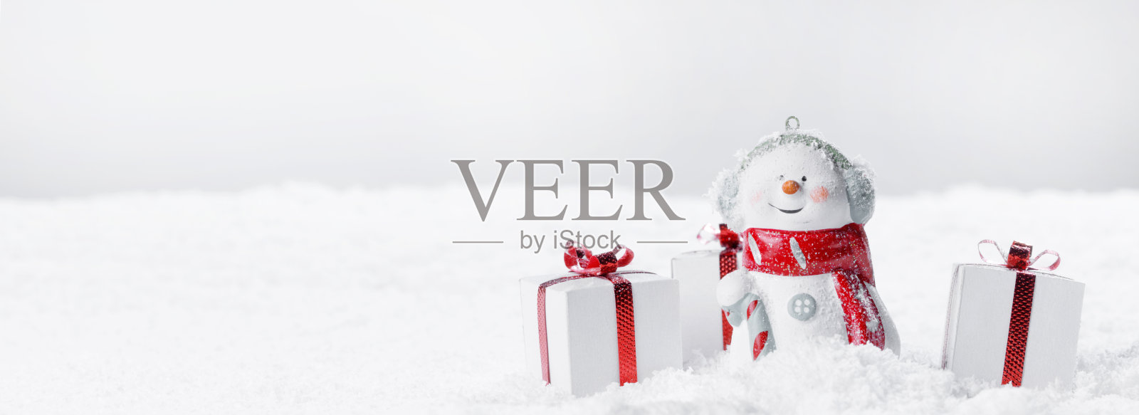 拿着圣诞礼物的雪人照片摄影图片