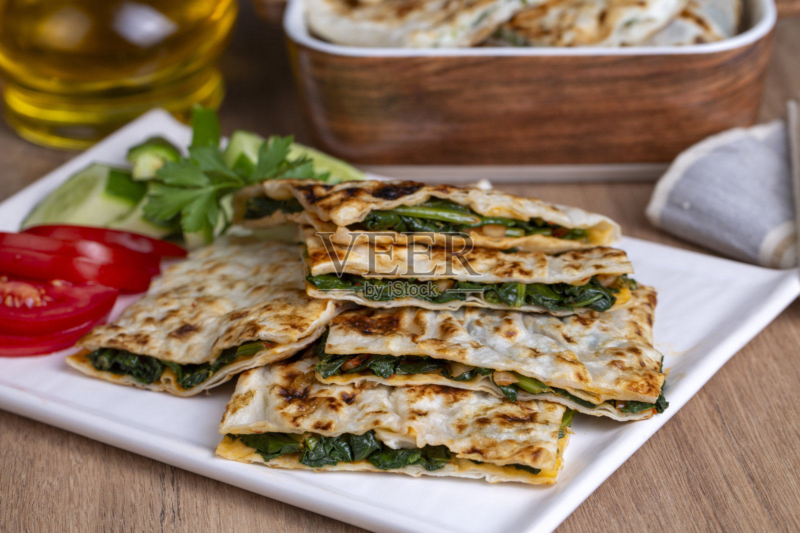 土耳其煎饼上有奶酪和香草。开胃菜是土耳其糕点。有奶酪、菠菜、土豆等品种照片摄影图片