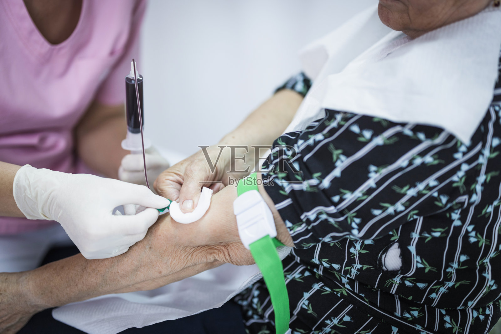 高级妇女在医生办公室验血照片摄影图片