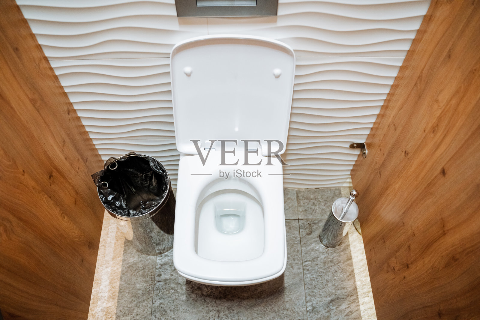 白色马桶打开顶盖，马桶里有水，垃圾桶里有水，卫生间里有需要的地方，厕所里有水。照片摄影图片