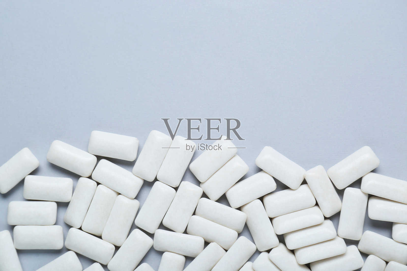 美味的白色口香糖，浅灰色的背景，平坦的躺着。文本空间照片摄影图片