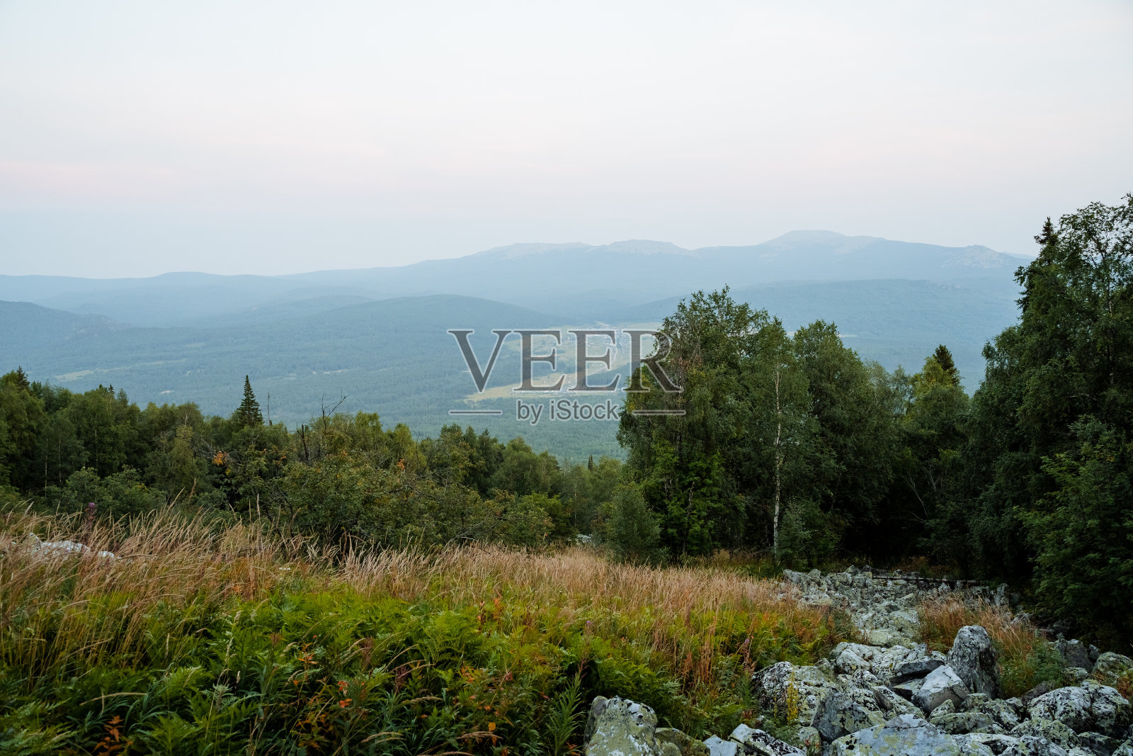 库鲁姆岭边林，山景多云，上有草，下有白桦林，下有石头。照片摄影图片