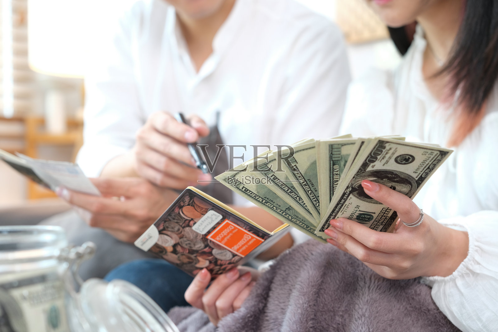 一对幸福的年轻亚洲夫妇正在攒钱买房子。男女夫妇为家庭和家庭存钱照片摄影图片