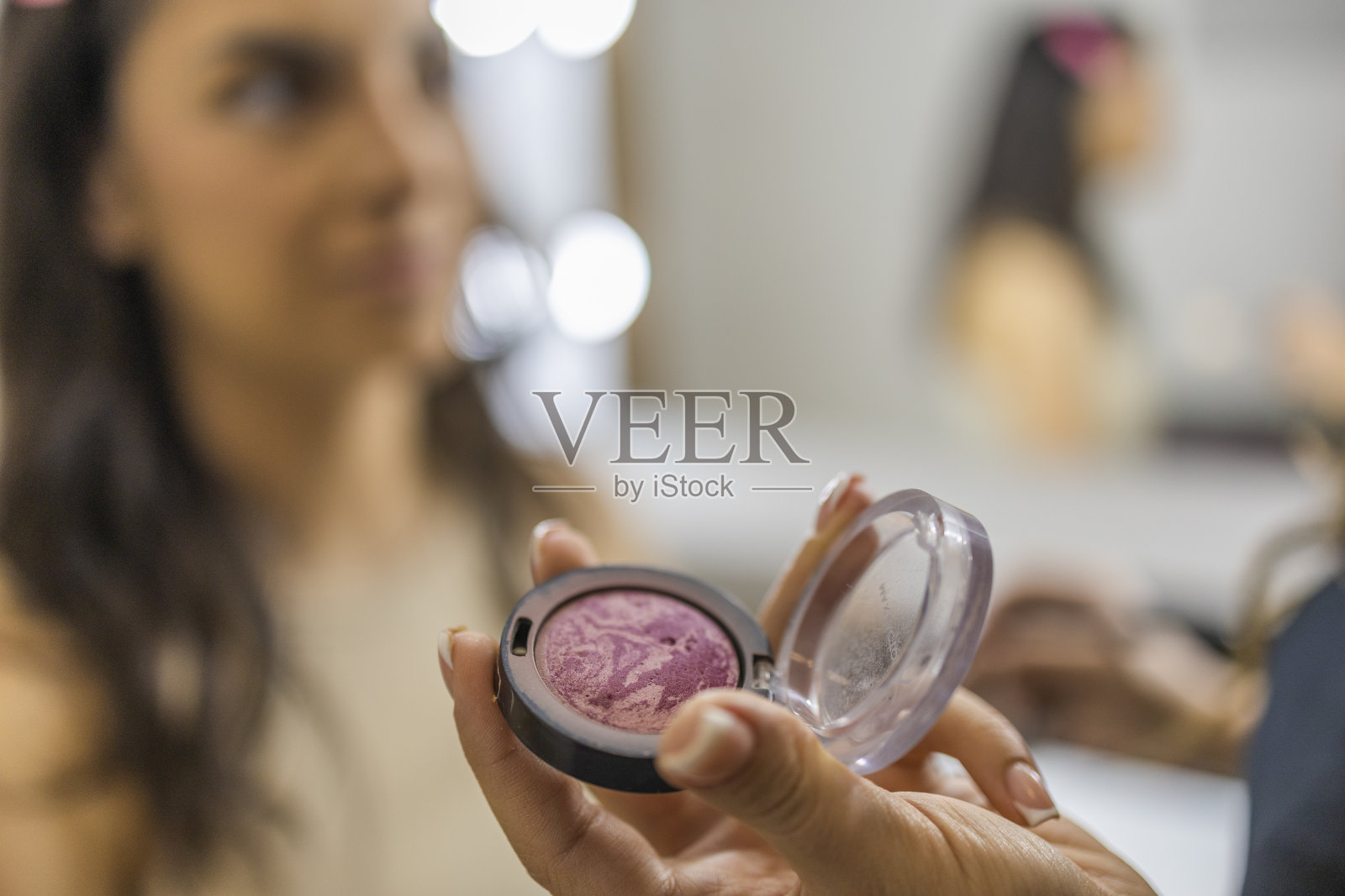 化妆腮红产品。化妆师手里拿着腮红。照片摄影图片