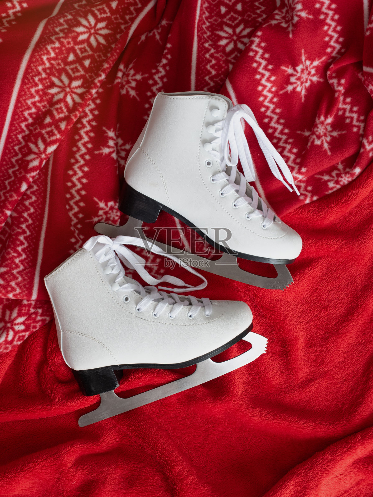 红色背景上的溜冰鞋和围巾照片摄影图片