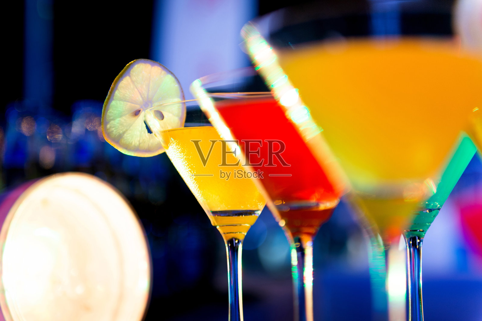 一群五颜六色的鸡尾酒在马提尼杯里喝照片摄影图片
