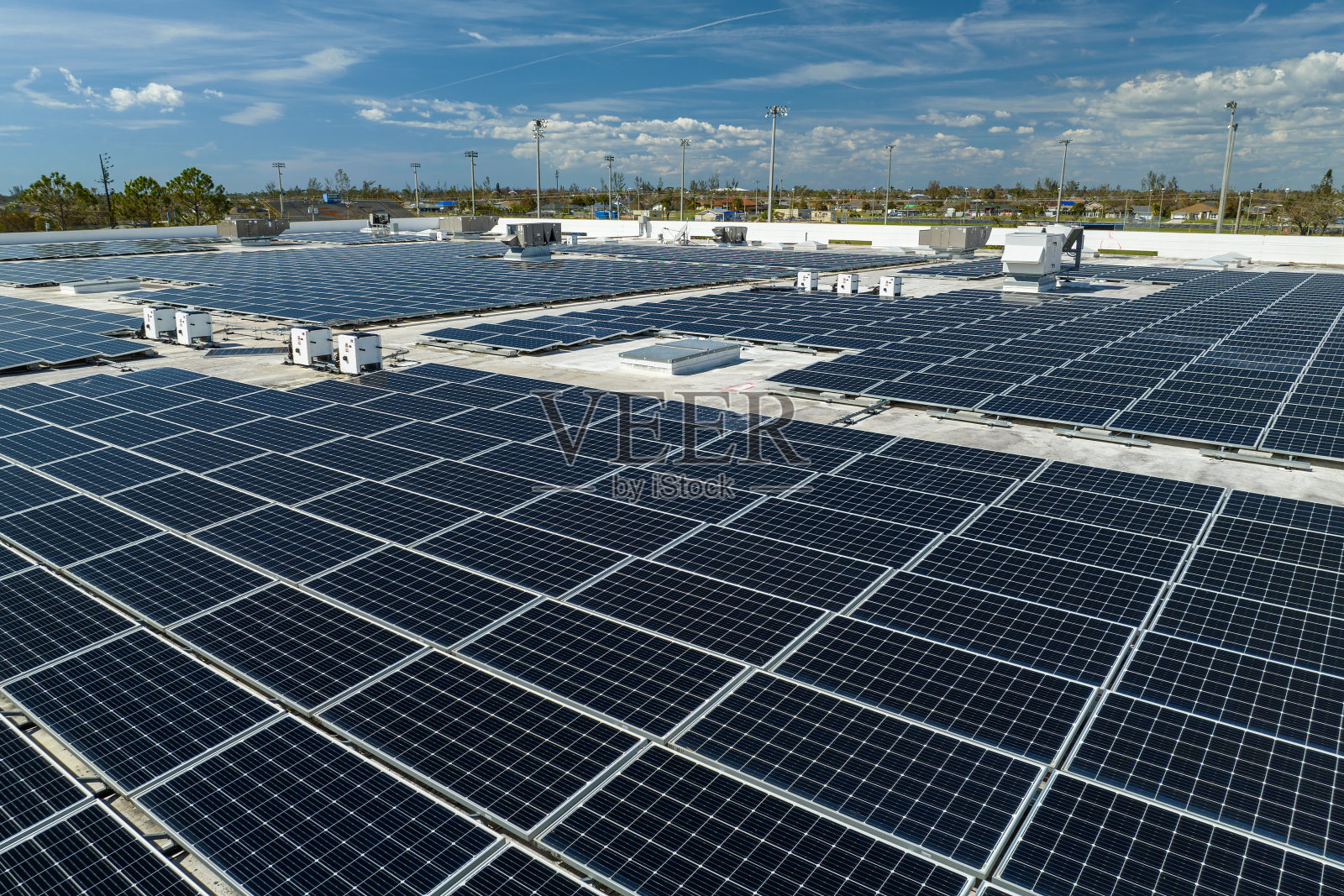 鸟瞰安装在工业建筑屋顶上的蓝色光伏太阳能板，产生绿色生态电力。生产可持续能源的理念照片摄影图片