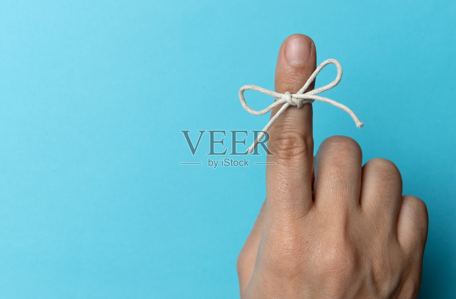 手和绳子系在食指上照片摄影图片