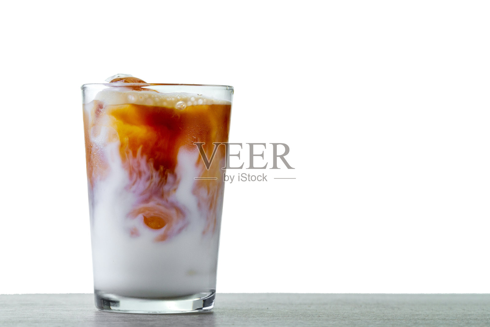 一杯清凉的咖啡鸡尾酒，白色背景上有泡沫和冰块，复制空间照片摄影图片