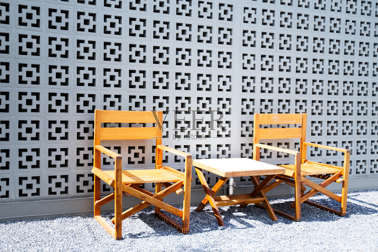 带靠背的木椅与岩石花园中的小木桌搭配在一起，让人放松照片摄影图片