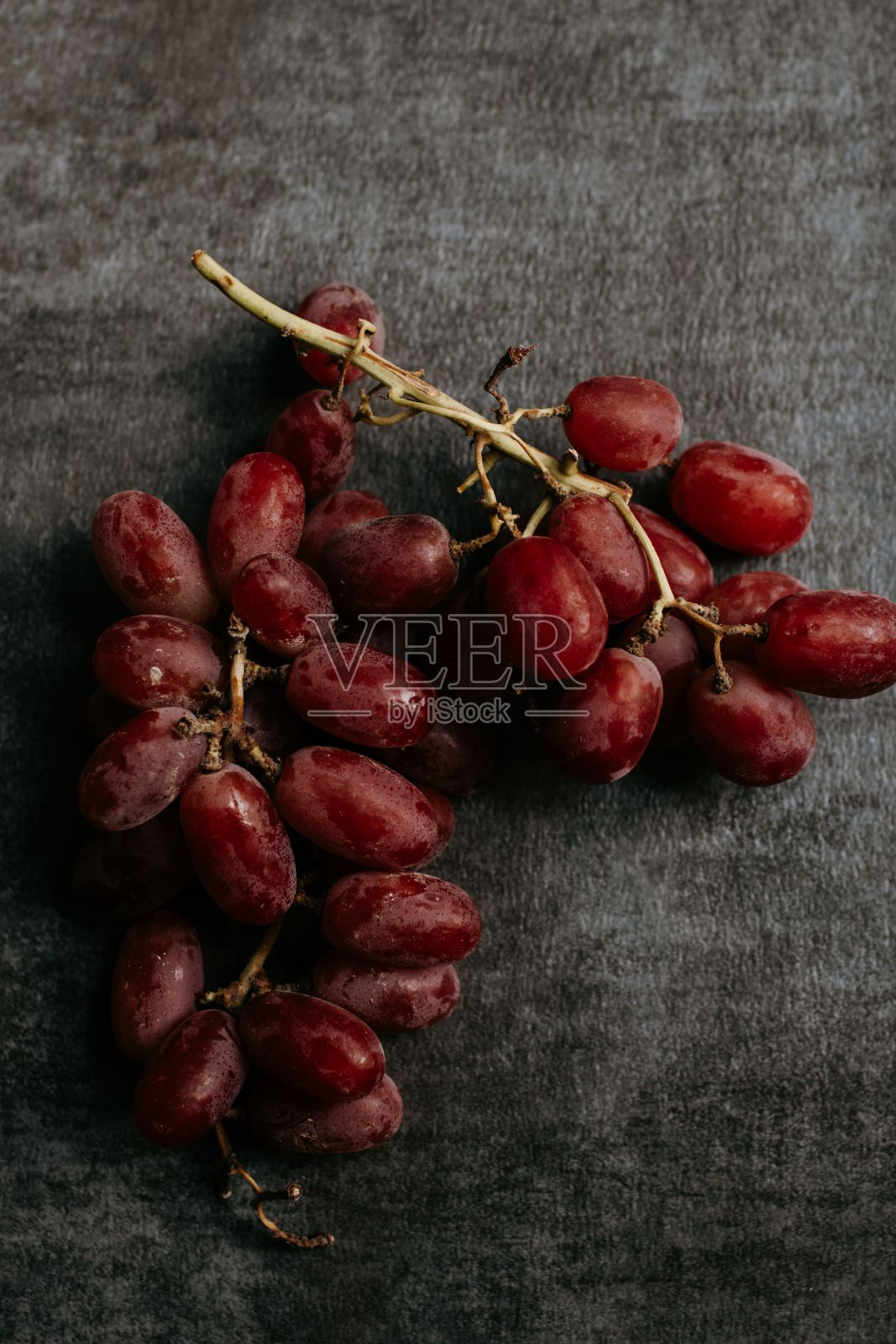 木桌上放着一颗红葡萄照片摄影图片