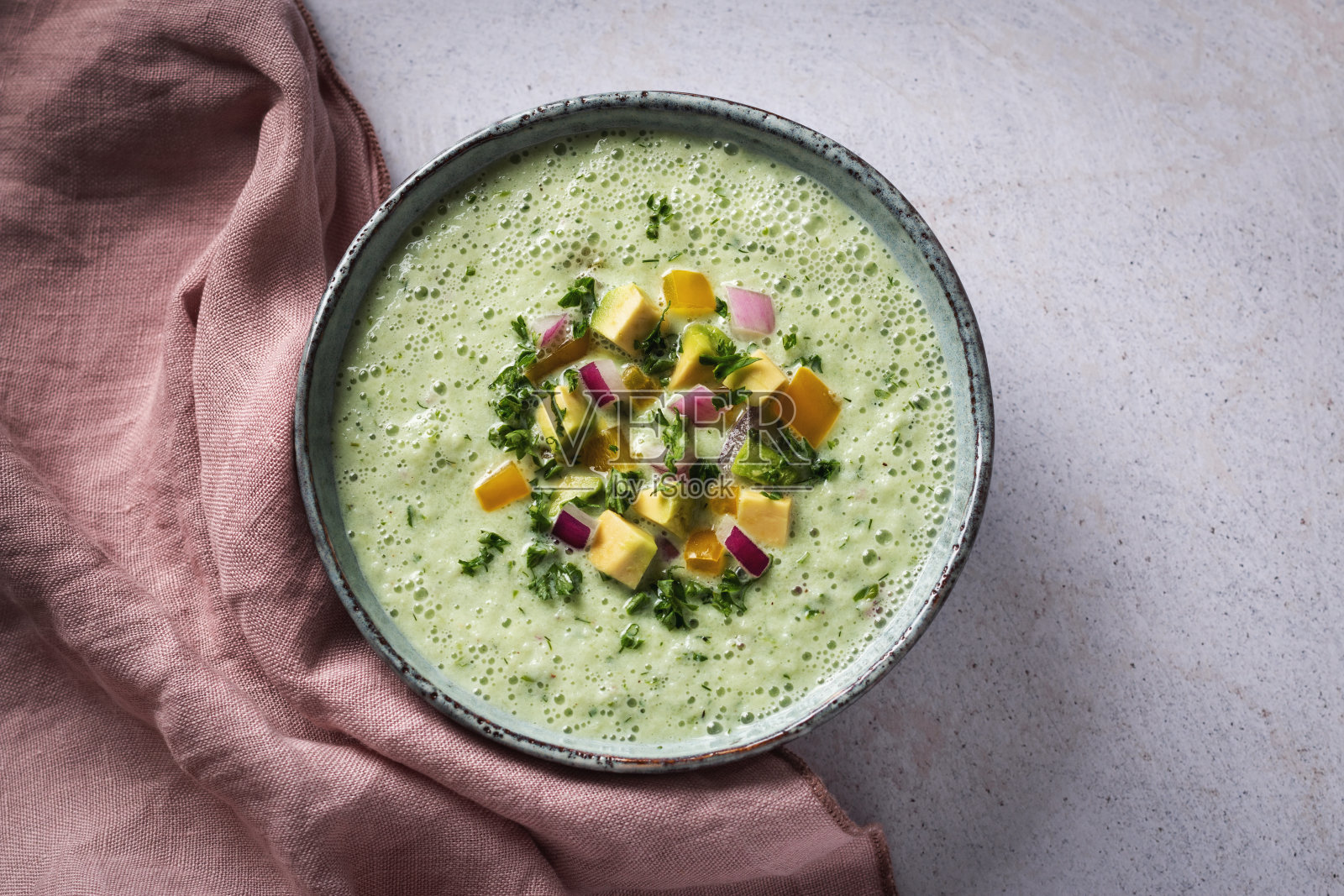 牛油果香草汤配松脆蔬菜浇头，以质朴的碗装饰照片摄影图片