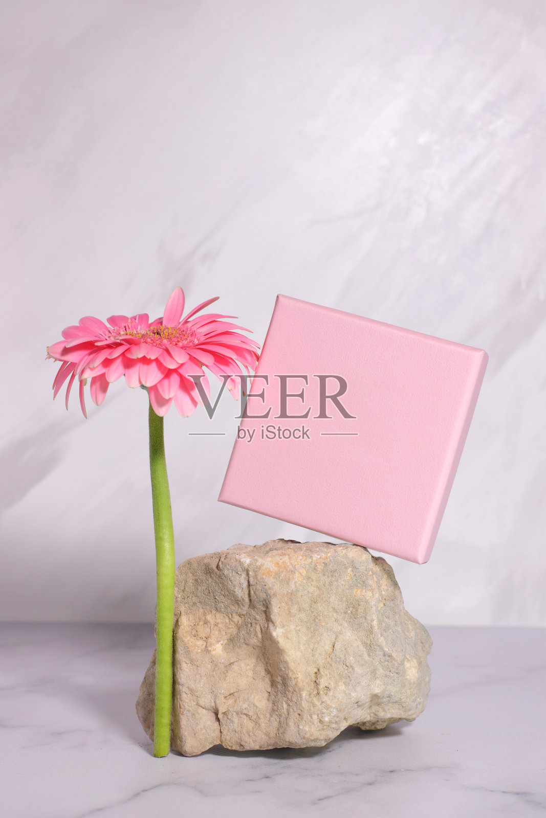 粉红色的礼盒上的石头和花的模型，目前的包装模拟照片摄影图片