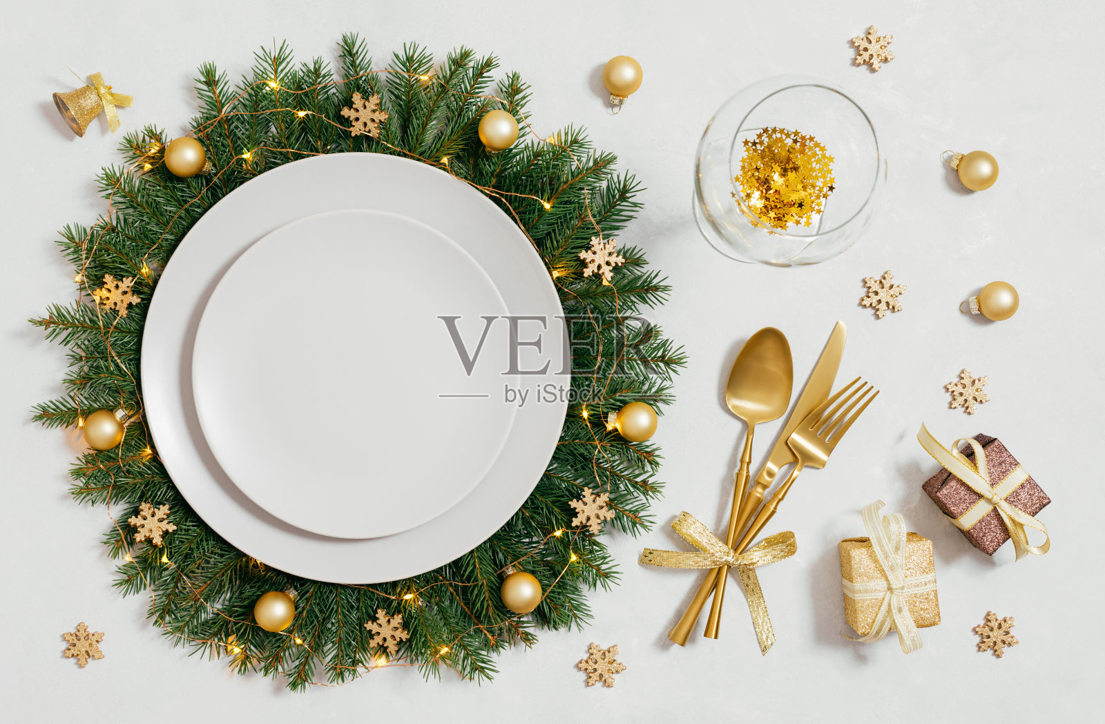 圣诞餐桌设置与空盘子和金色配件在白色背景。圣诞花环盘。新年晚会。俯视图，平铺。照片摄影图片