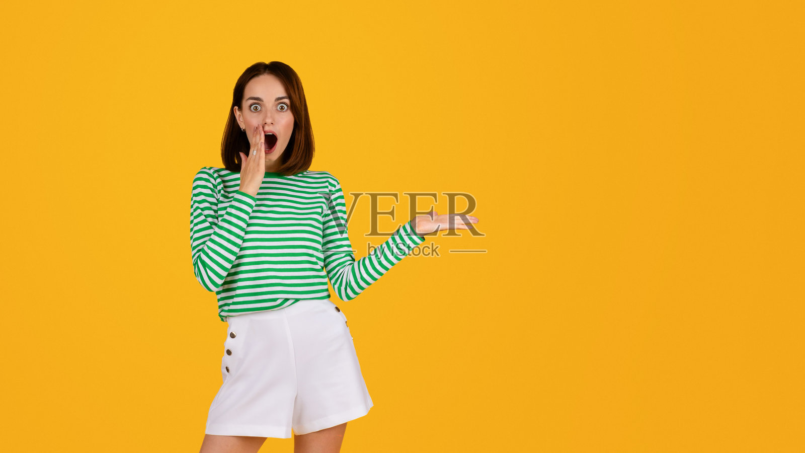 震惊的千禧一代女性手里拿着看不见的东西照片摄影图片