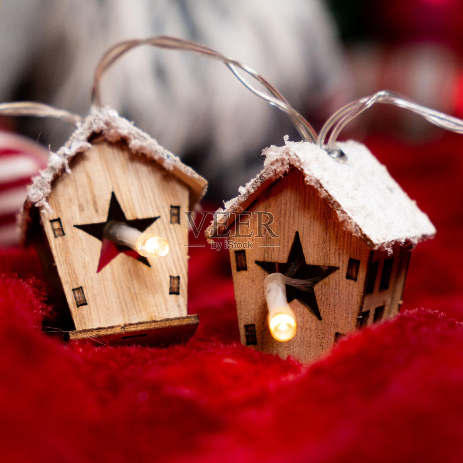 木制房屋形状的发光花环。美丽的圣诞和新年贺卡。照片摄影图片