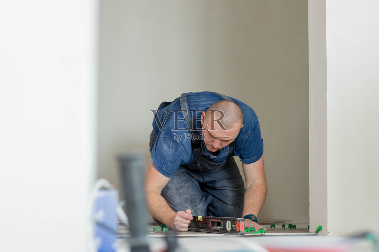 一位男建筑工人正在安装一块大瓷砖照片摄影图片