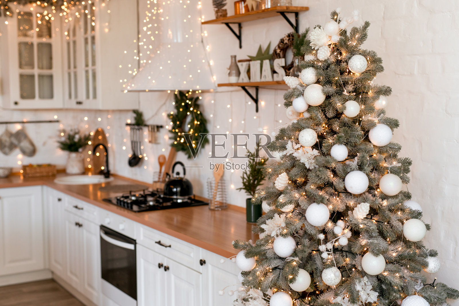 现代厨房内饰与岛，水槽，橱柜在新的豪华家居装饰在圣诞风格。照片摄影图片