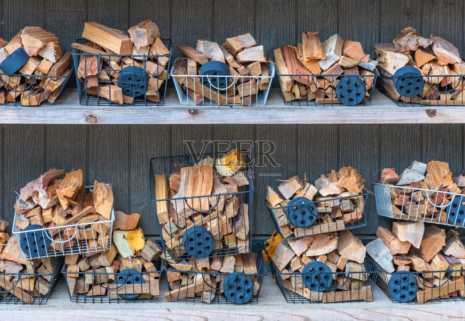 装有木炭和原木的篮子放在架子上，用作野营的壁炉。照片摄影图片