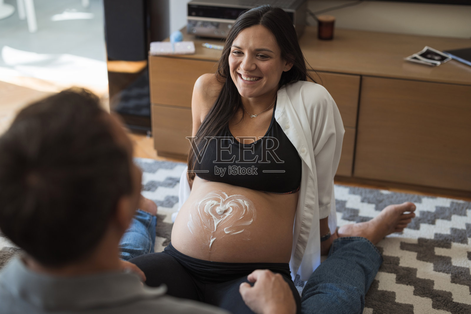 孕妇在腹部涂抹面霜照片摄影图片