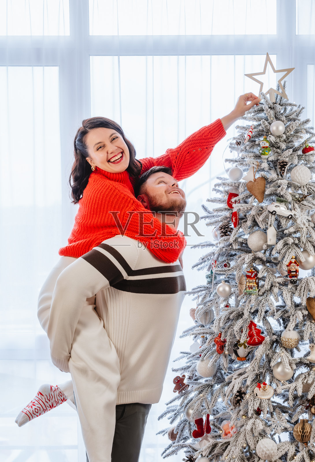 一对夫妇正在装饰圣诞树照片摄影图片
