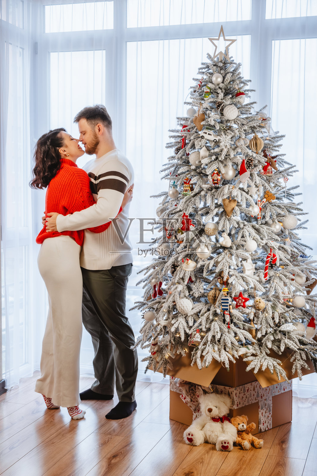 可爱的情侣在圣诞树前跳舞照片摄影图片