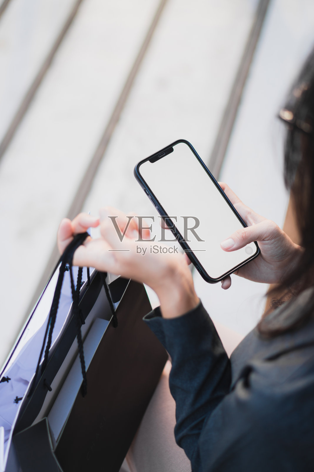 年轻女子或十几岁的女孩手拿智能手机与模拟白色空白显示照片摄影图片