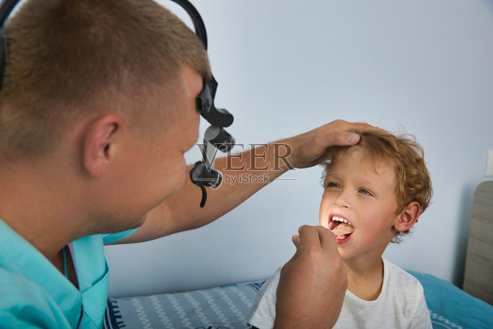 男孩大胆地张开嘴，让医生检查喉咙的情况照片摄影图片