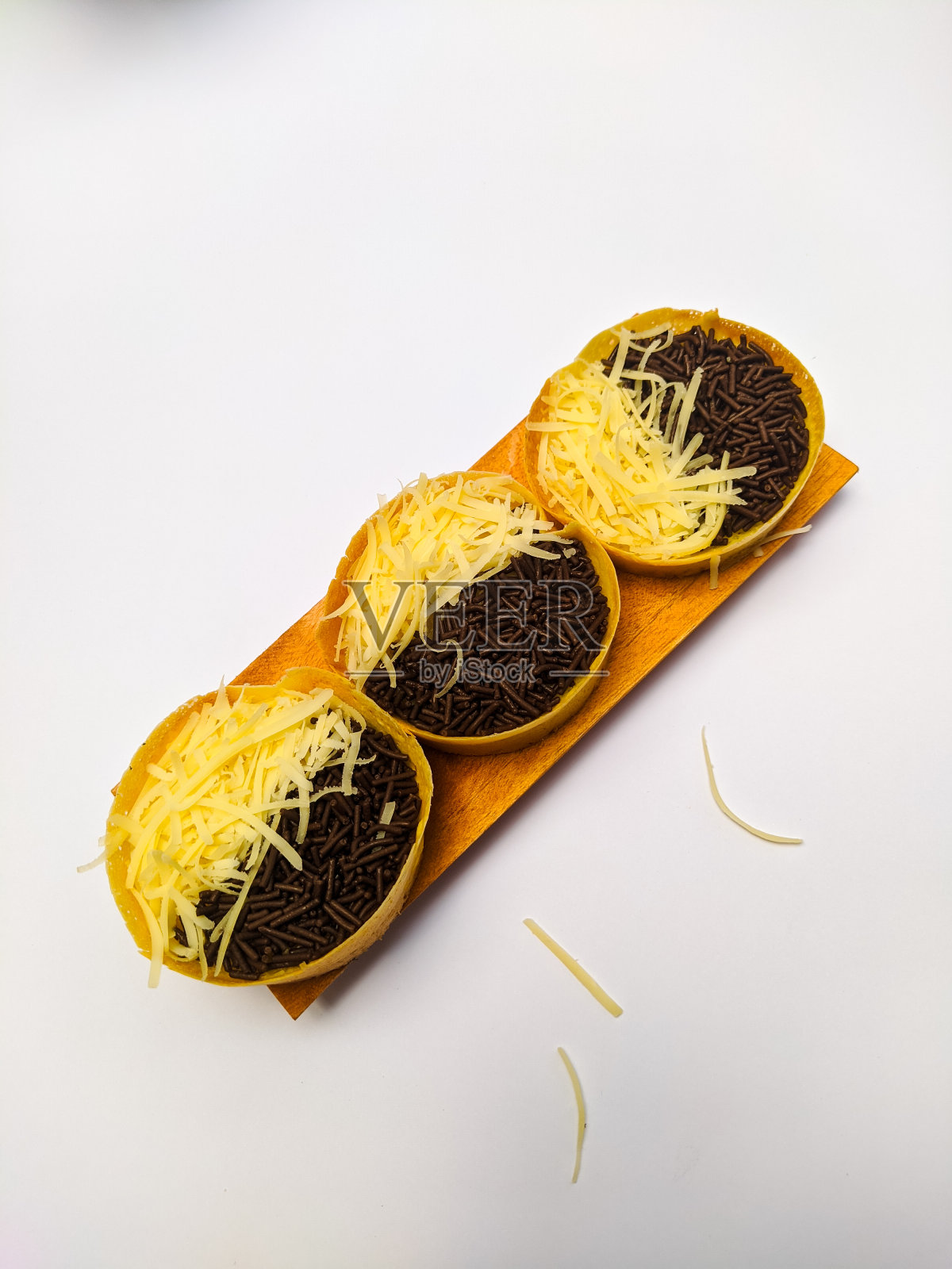 迷你Martabak或Terang Bulan或厚厚的印度尼西亚煎饼，上面有巧克力和奶酪，是一种受欢迎的印度尼西亚小吃，质地柔软甜美。在白色背景下照片摄影图片