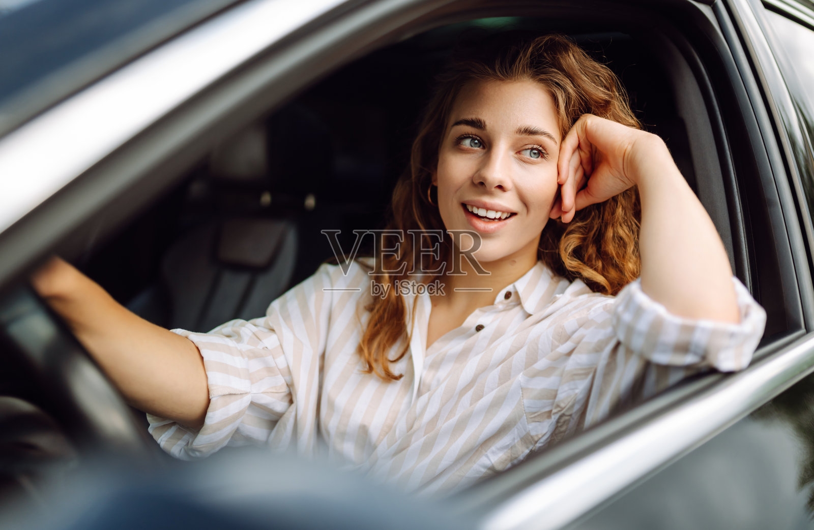 微笑的女人在开车。照片摄影图片