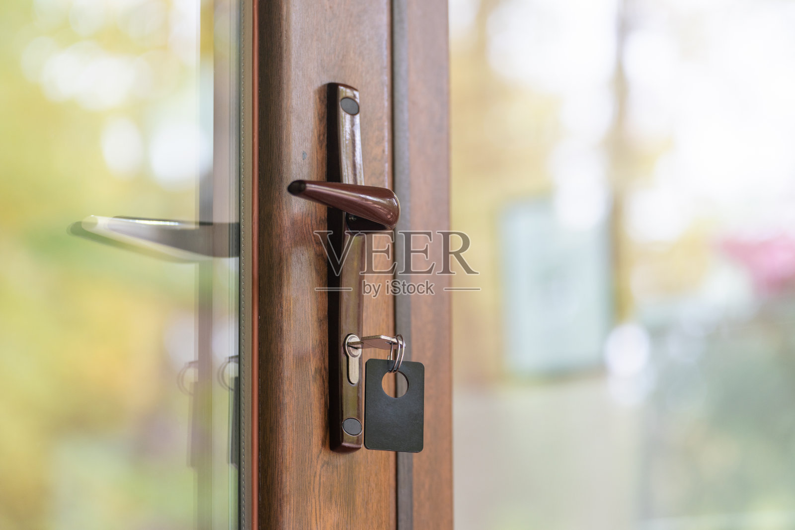 在关着的门的锁孔里有钥匙链的钥匙照片摄影图片