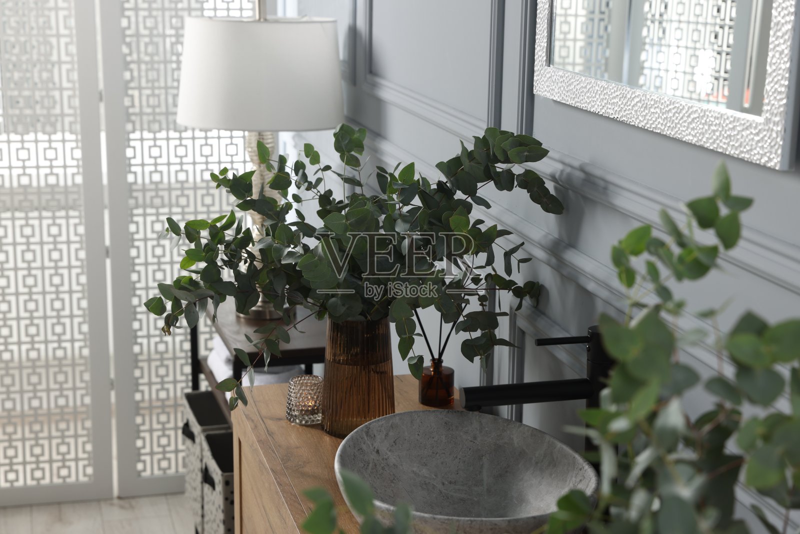 浴室梳妆台上水槽附近的桉树树枝。室内设计照片摄影图片