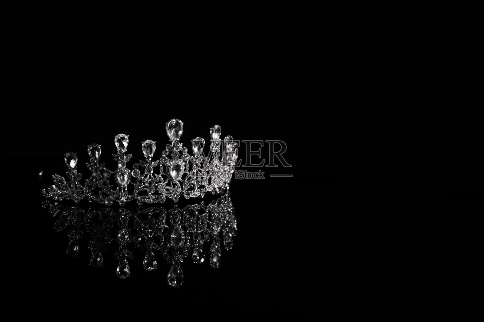 美丽的银王冠与钻石在黑暗的镜面。文本空间照片摄影图片