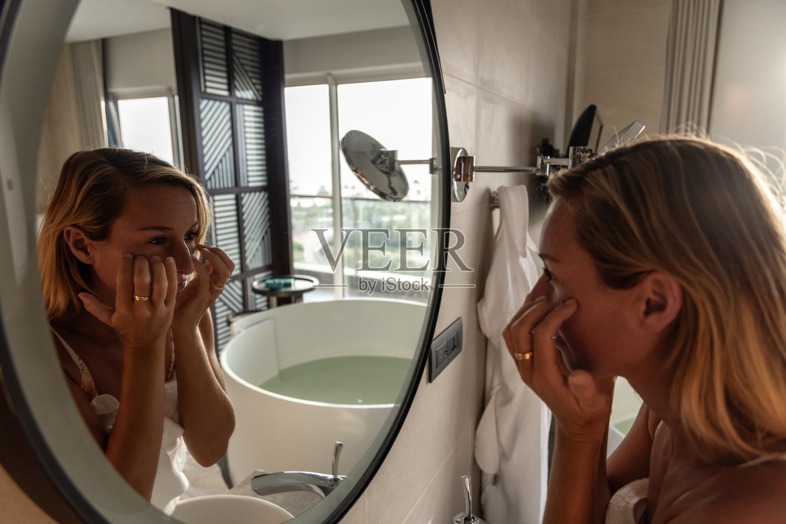 洗完澡后，浴室里的女人在照顾自己的皮肤照片摄影图片