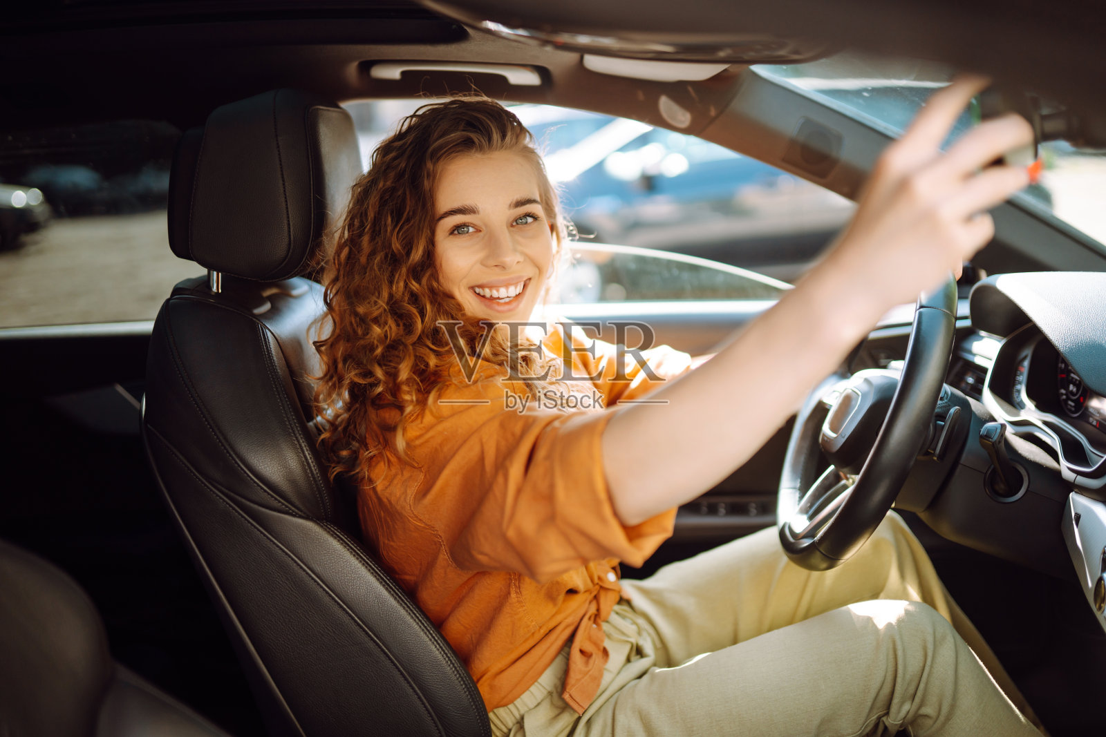 一个漂亮的年轻女子开车的画像。照片摄影图片
