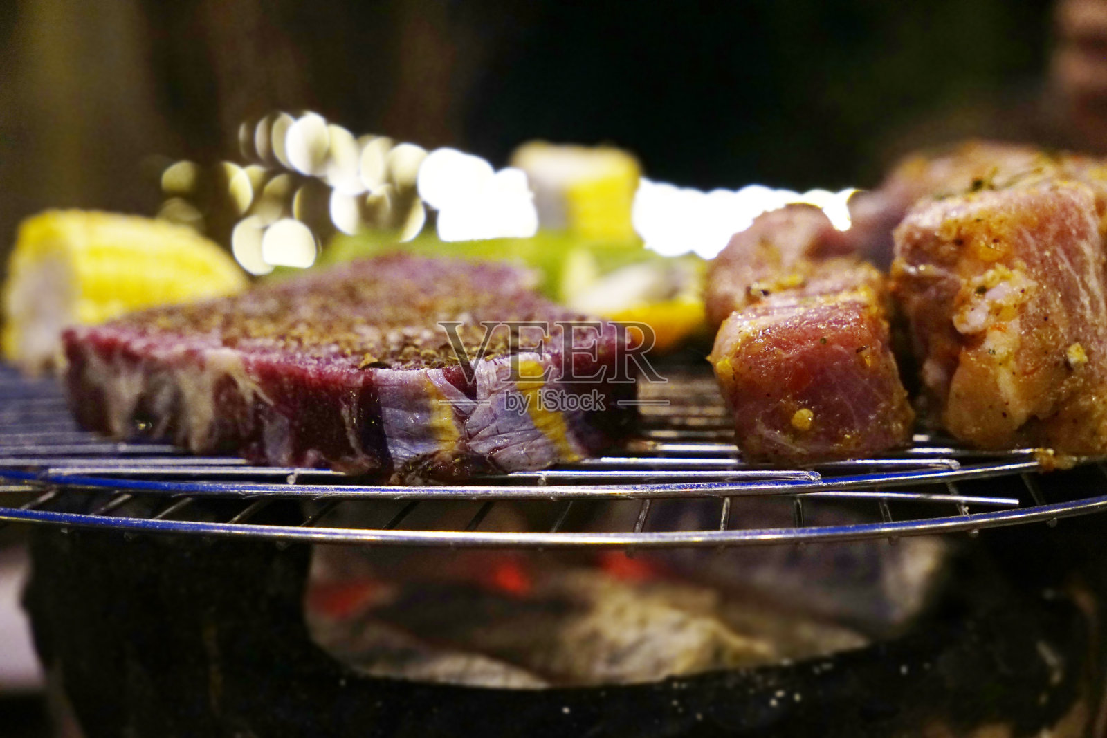 在煤烤炉上的腌牛排和排骨的特写照片照片摄影图片