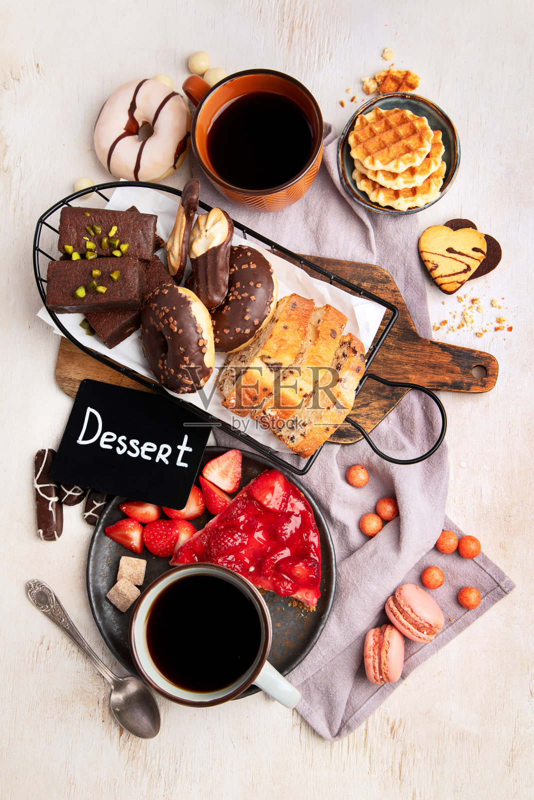 一杯咖啡配上华夫饼、饼干、蛋糕和甜甜圈。热饮和甜点照片摄影图片