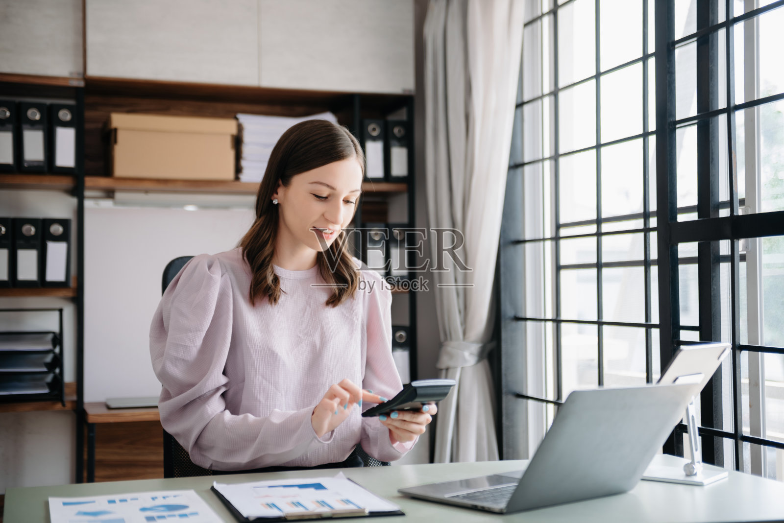 漂亮的商务女性打字笔记本电脑和平板电脑放在办公室的桌子上照片摄影图片