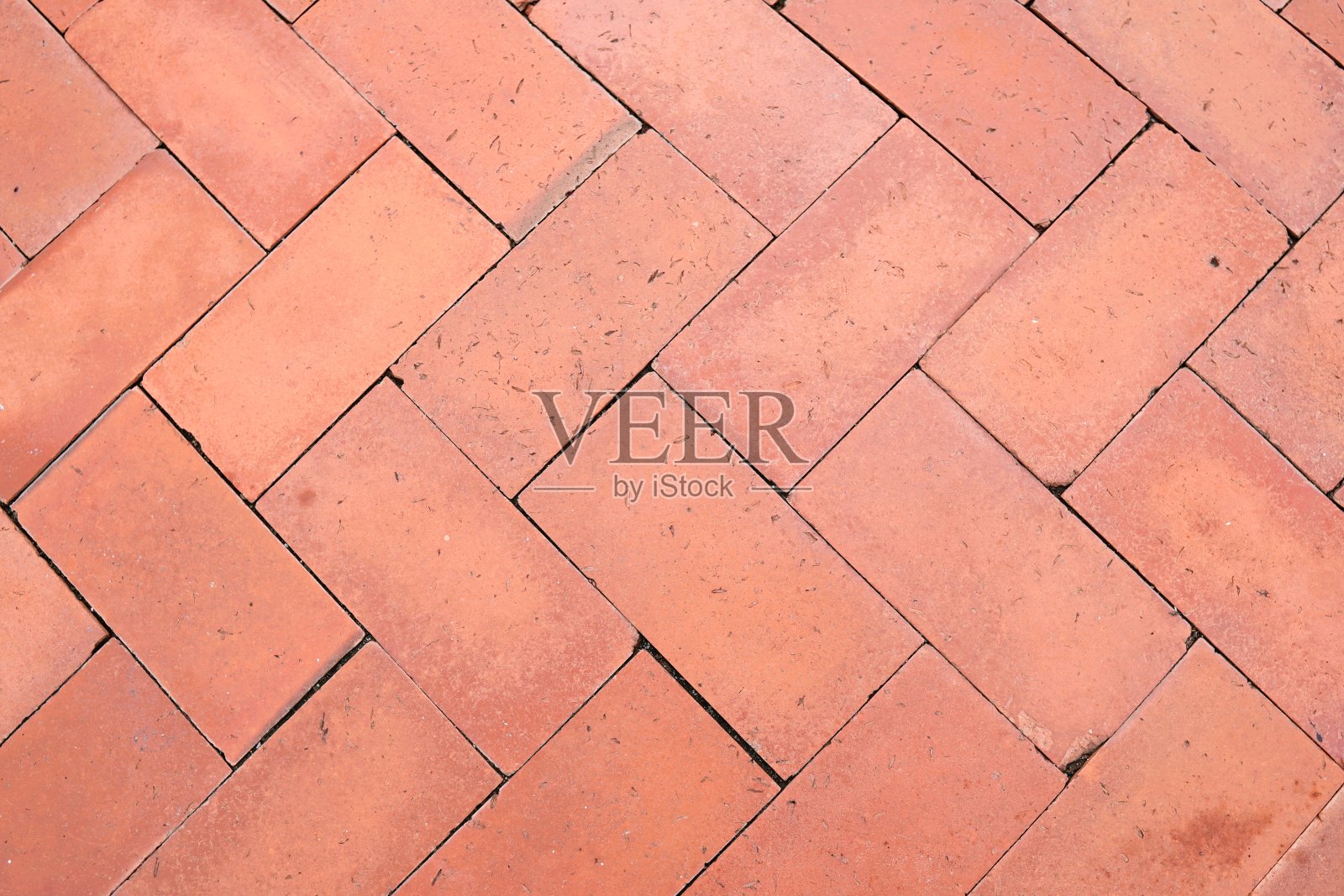 背景图像是一条由红砖排列在一起的人行道，看起来很漂亮。照片摄影图片