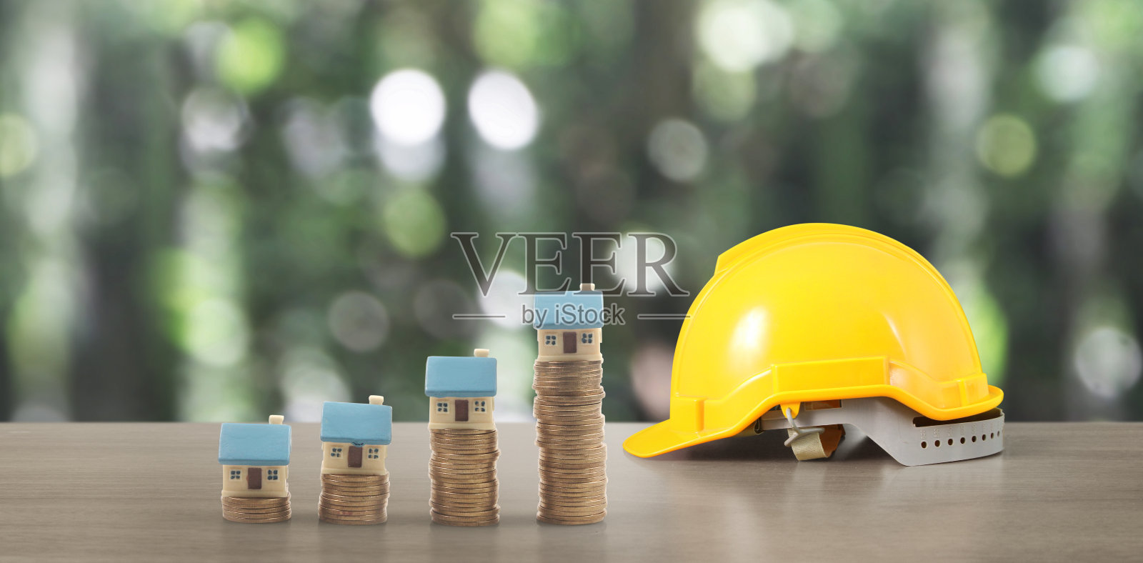 黄色安全帽样板房和带有交易图的硬币照片摄影图片