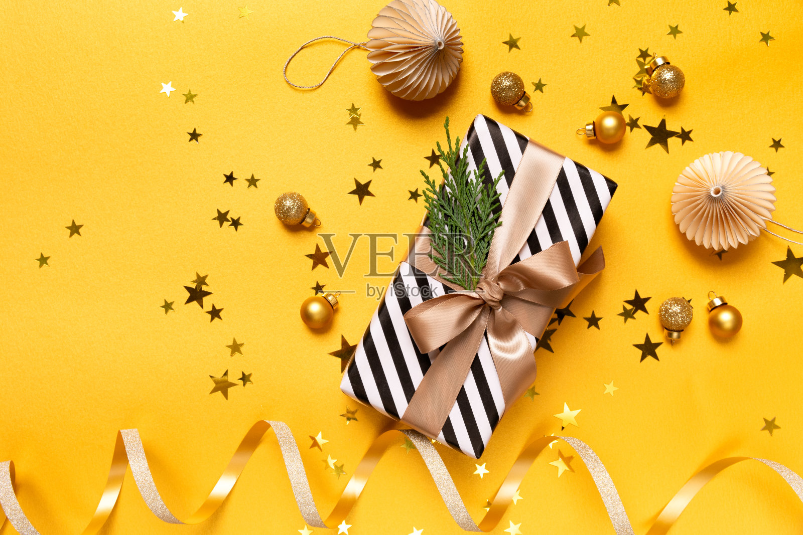 圣诞礼物，礼品盒和节日装饰在黄色背景。圣诞新年背景。照片摄影图片