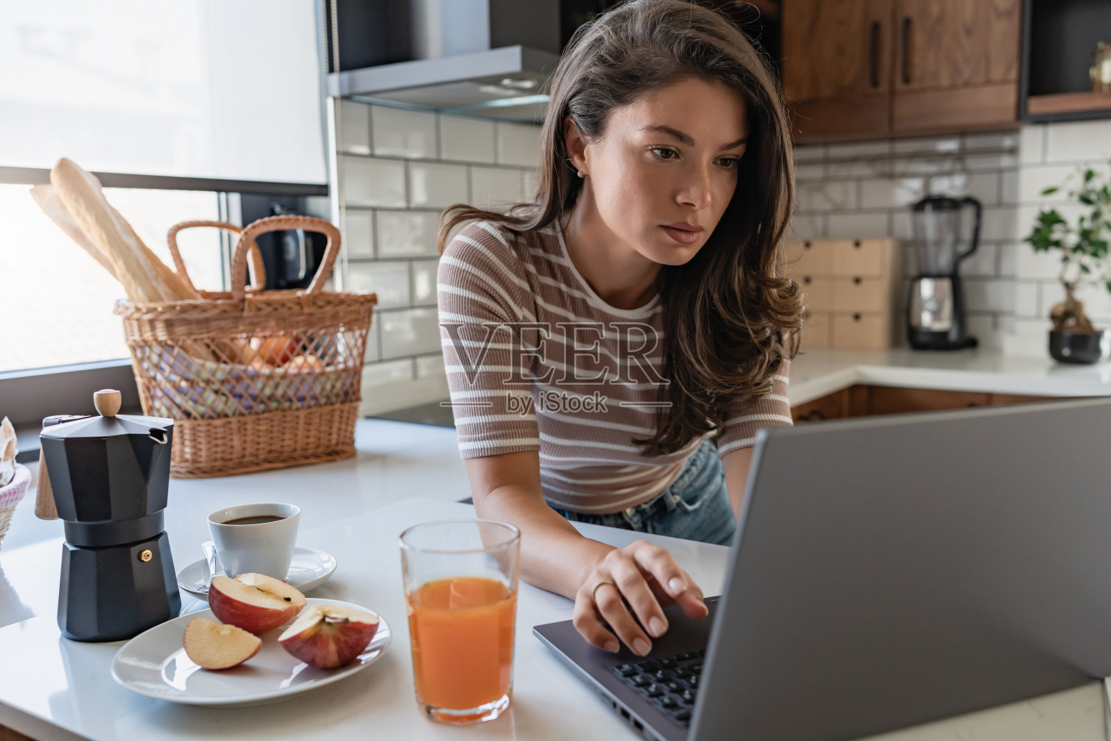 年轻的女企业家在家工作，看文件和使用笔记本电脑照片摄影图片