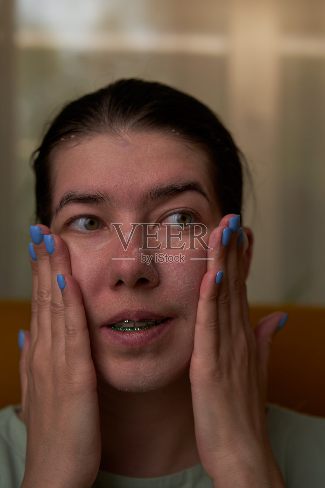 女人正在用泡沫洗脸。照片摄影图片