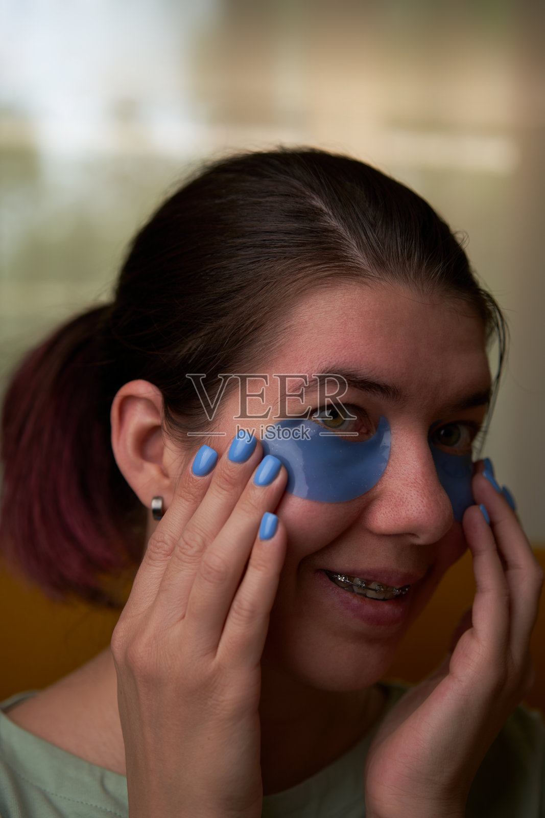 女人正在用化妆贴片敷脸。照片摄影图片