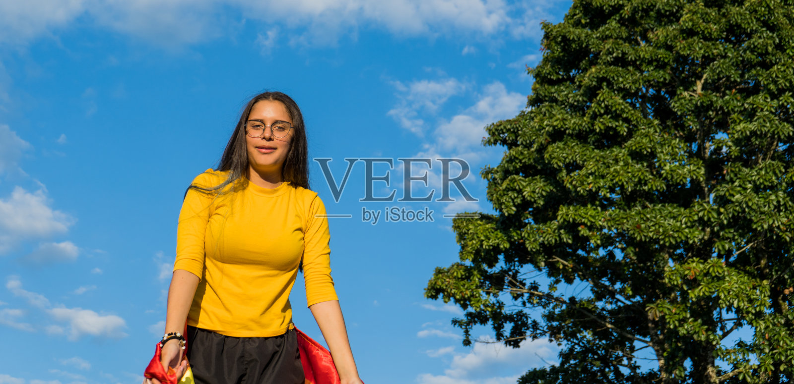 戴着眼镜、留着长发的年轻女子在户外微笑照片摄影图片