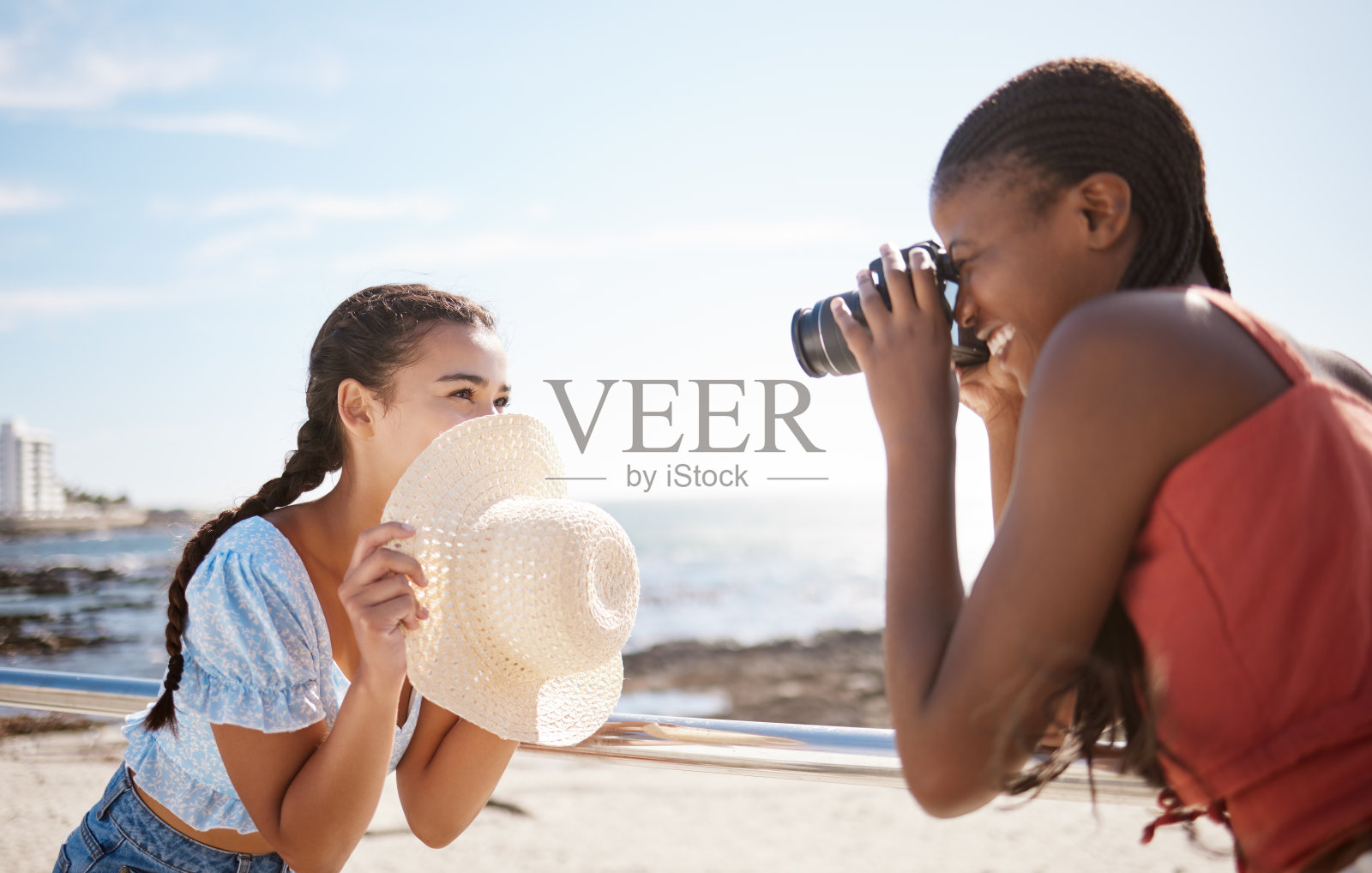 摄影师、女人和模特在夏日的沙滩上拍摄一组创意十足、自由快乐的户外照片。摄影，微笑和有趣的女孩拿着相机，专注于女性和海洋背景照片摄影图片