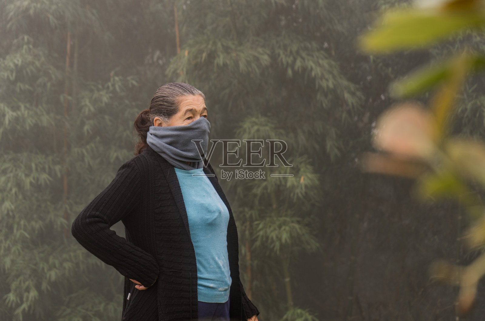 戴着围巾和外套在户外散步的成年妇女照片摄影图片